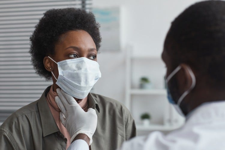 A nurse practitioner examines a patient.