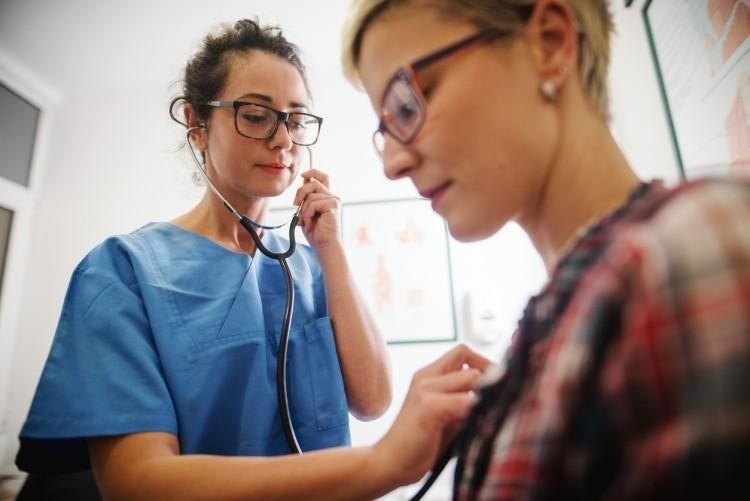 A certified nurse practitioner examines a patient.