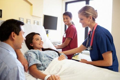 Two nurses meeting with a couple in a hospital room.