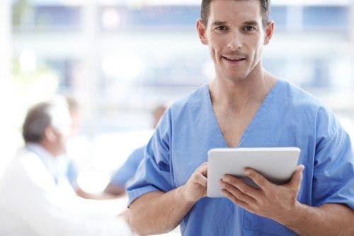 A chief nursing officer holds a tablet.