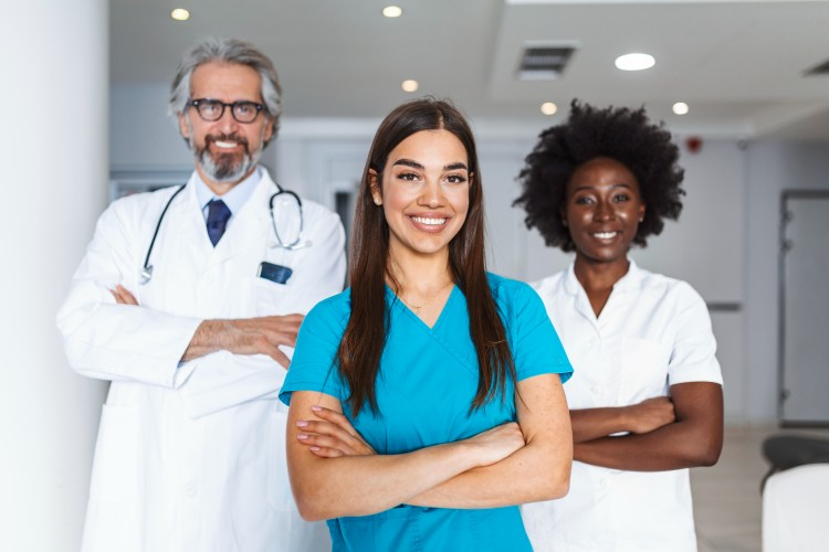 A local travel nurse stands with two colleagues.